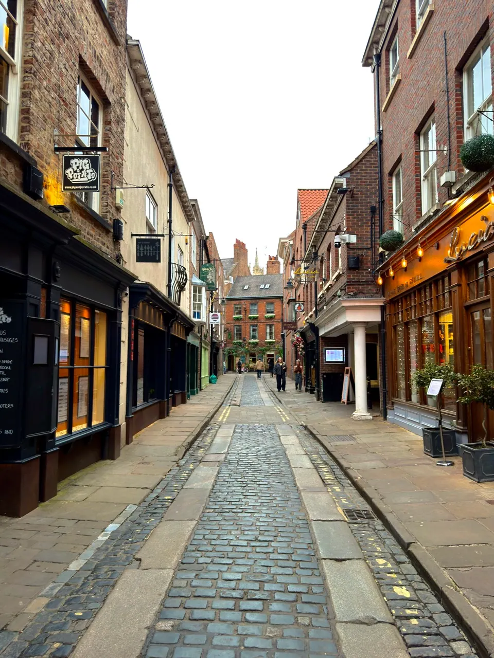 An empty cobbled shopping street runs between close-set buildings