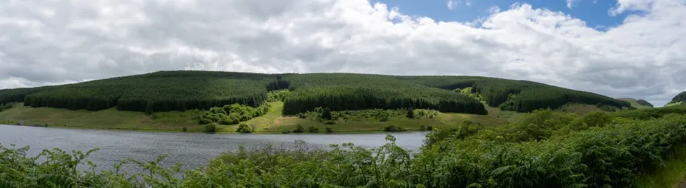 A panoramic reservoir view surrounded by green hills