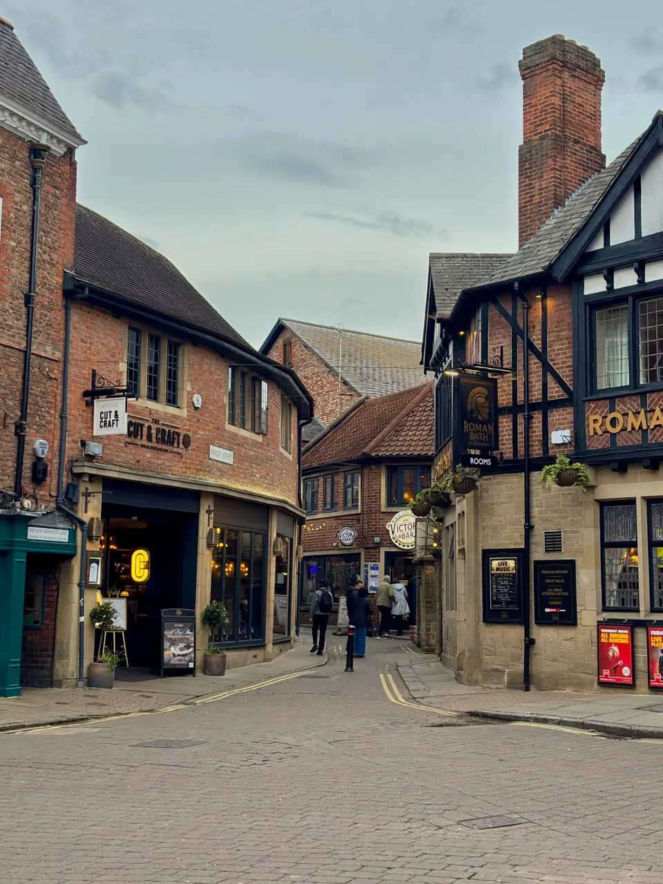 A narrow street winds past timber-framed buildings