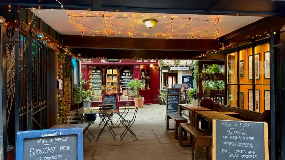 Cafe tables line a covered courtyard beneath warm lights
